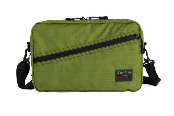 A Packing Cube Shoulder Bag in Moss (green with light green grid) 210 Cerylon with a shoulder strap attached